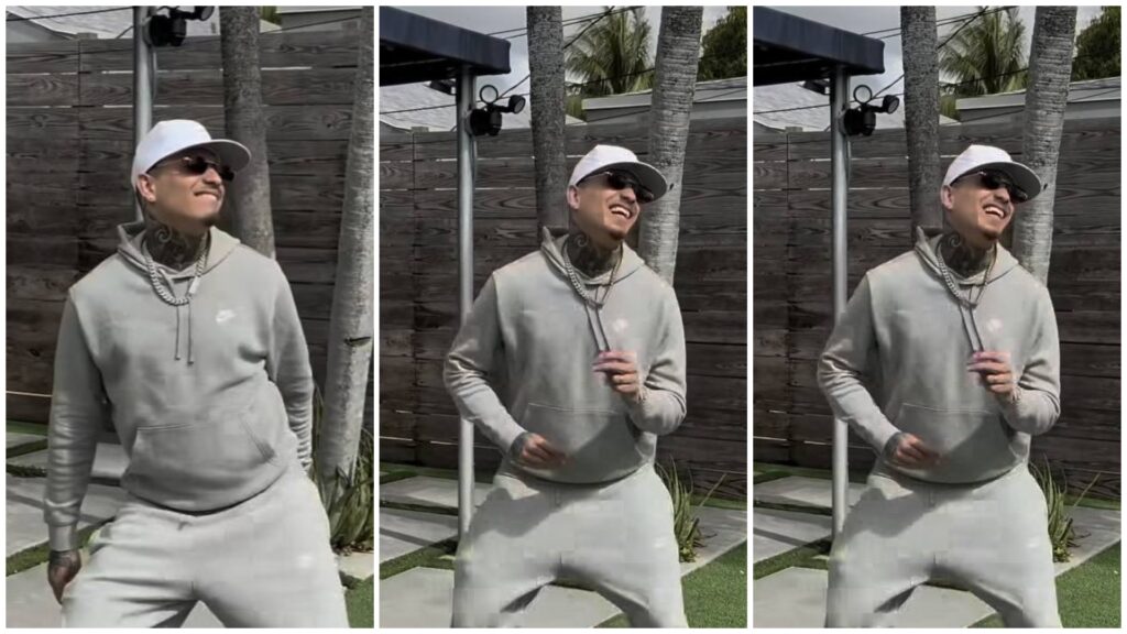 Hombre sonriente con gorra y cadena posando