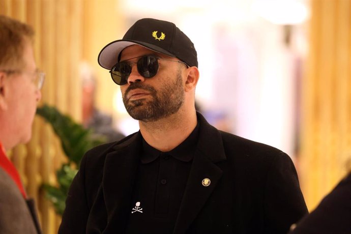 Hombre con gorra y gafas en interior elegante