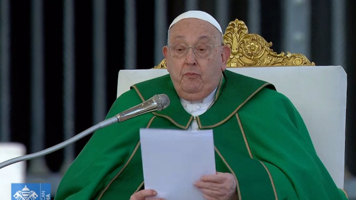 Hombre dando discurso en micrófono con sotana verde