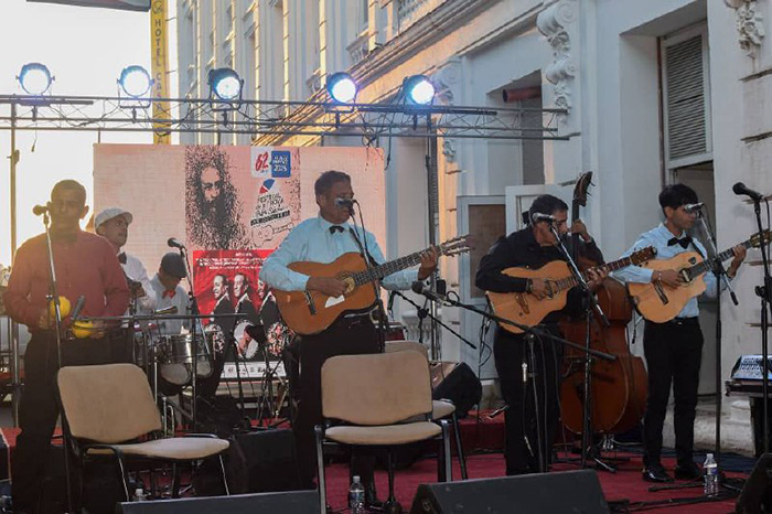 Grupo musical tocando en un escenario al aire libre.