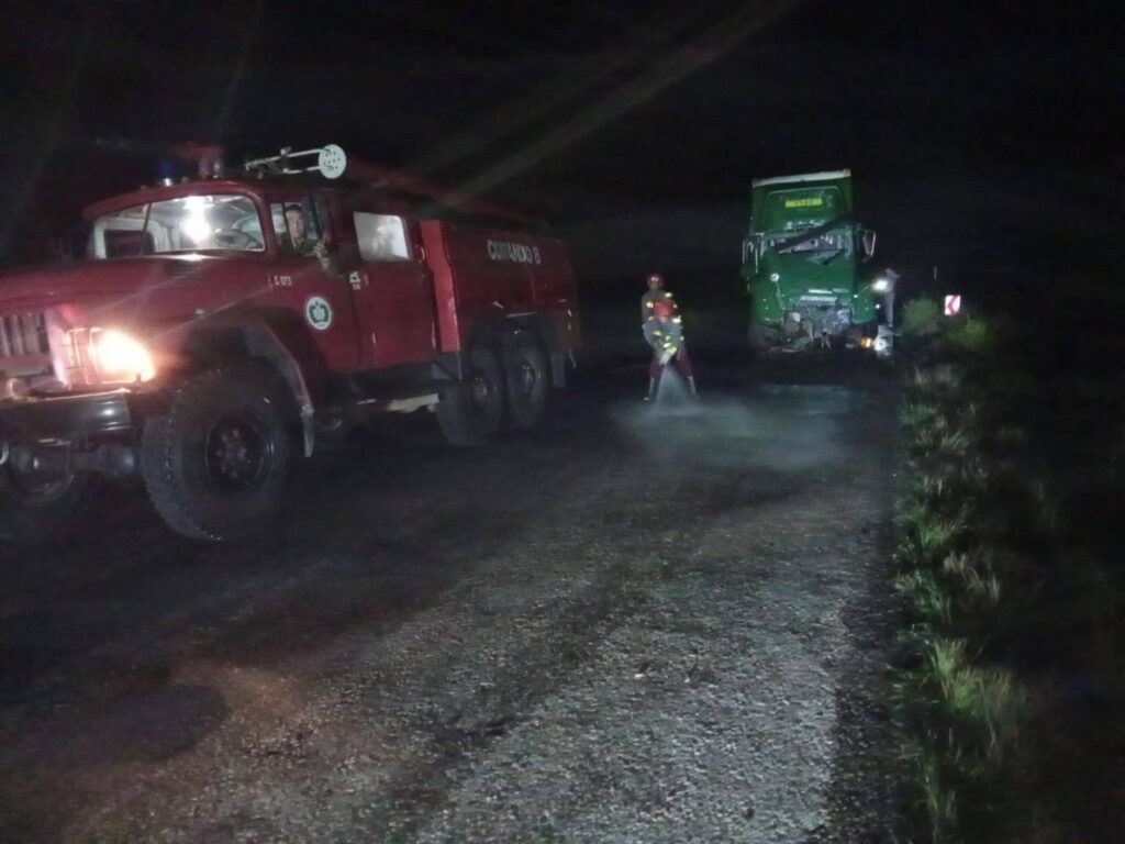 Camión de bomberos y camión accidentado en carretera