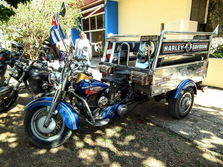 Motocicleta Harley-Davidson con sidecar y bandera cubana.