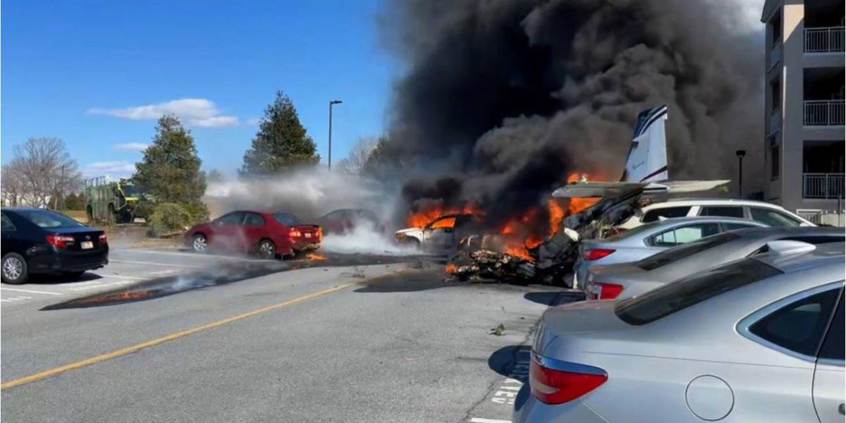 Accidente de avión en estacionamiento con incendio y humo.