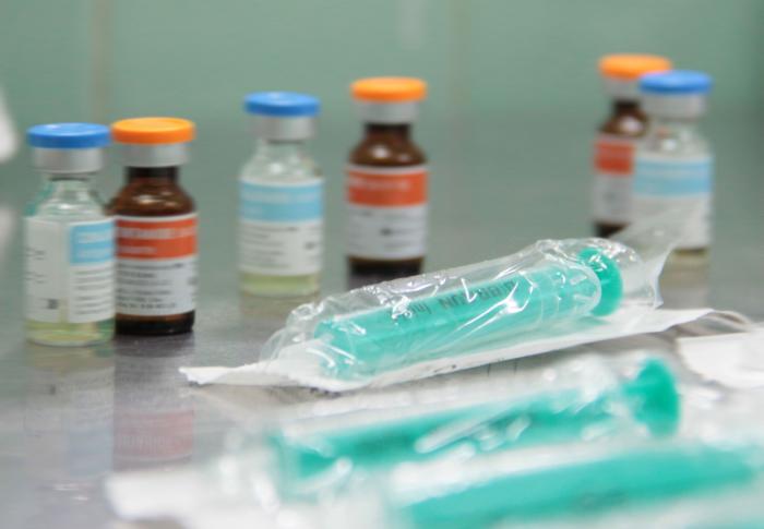 Viales y jeringas en una superficie médica.