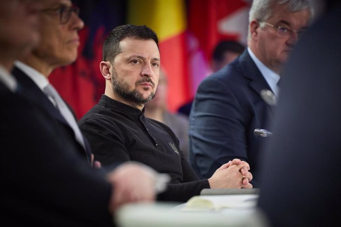 Hombre serio en reunión con banderas de fondo