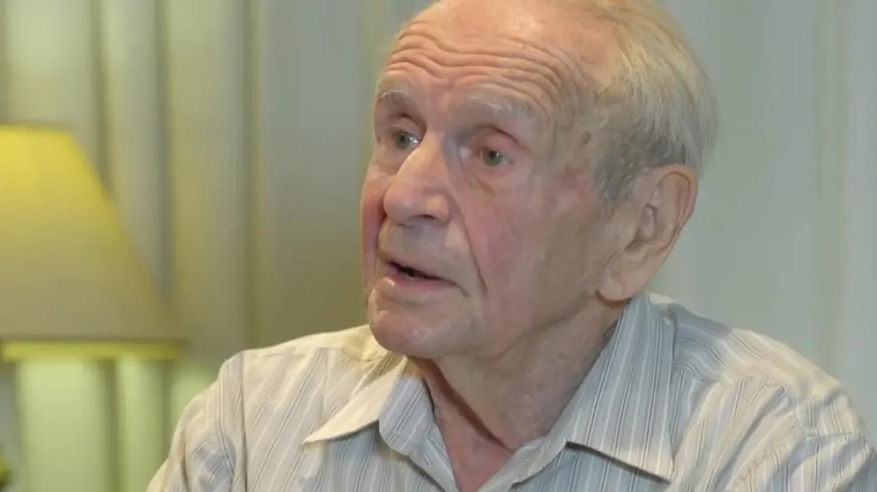 Hombre mayor con camisa, mirando a la derecha.