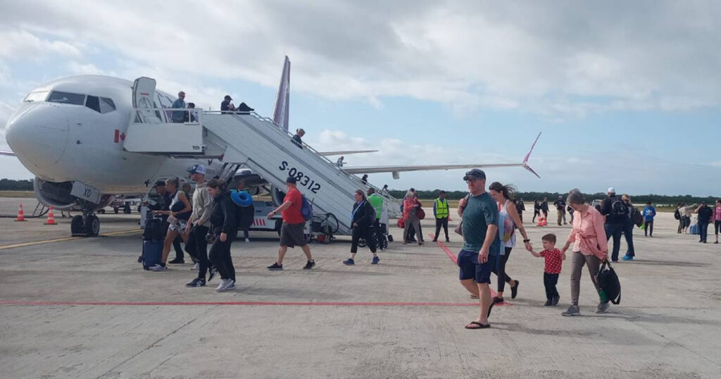 Pasajeros desembarcando de un avión en aeropuerto.