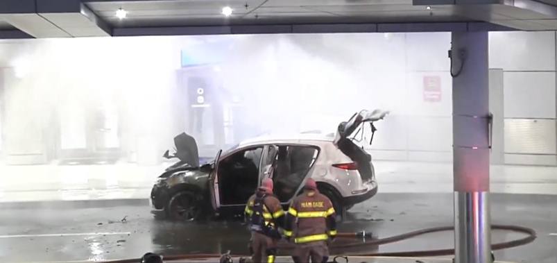 Bomberos apagan incendio en coche dañado.