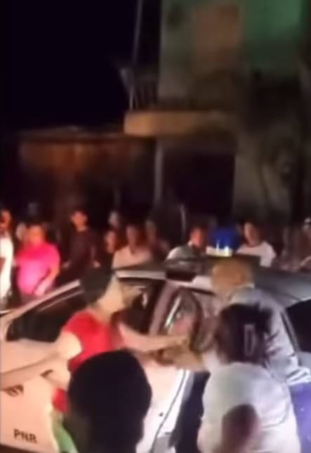 Multitud rodea coche durante la noche