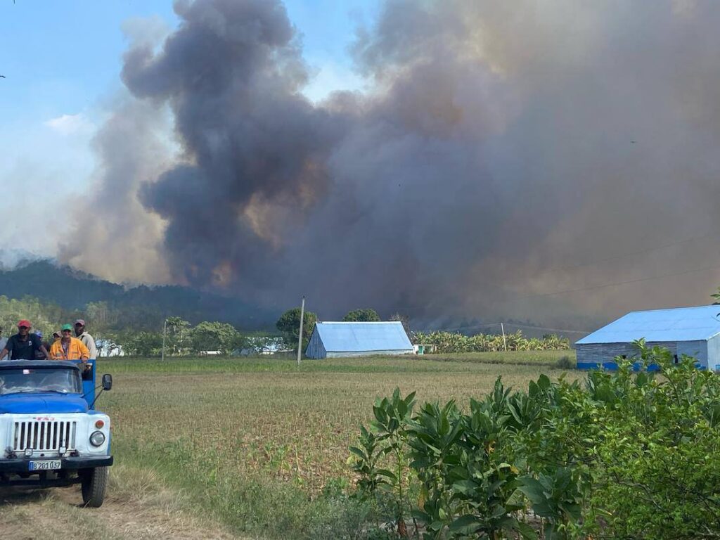 Incendio forestal con humo y personal de emergencia