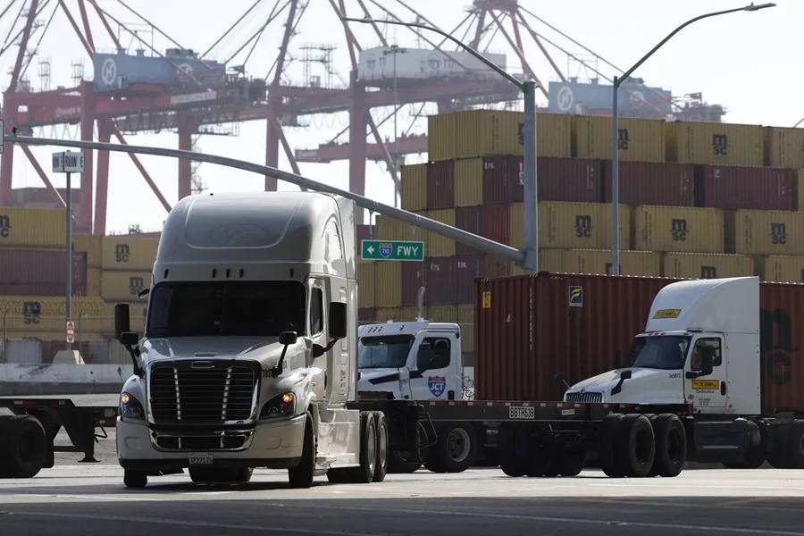 Camiones en puerto con contenedores.