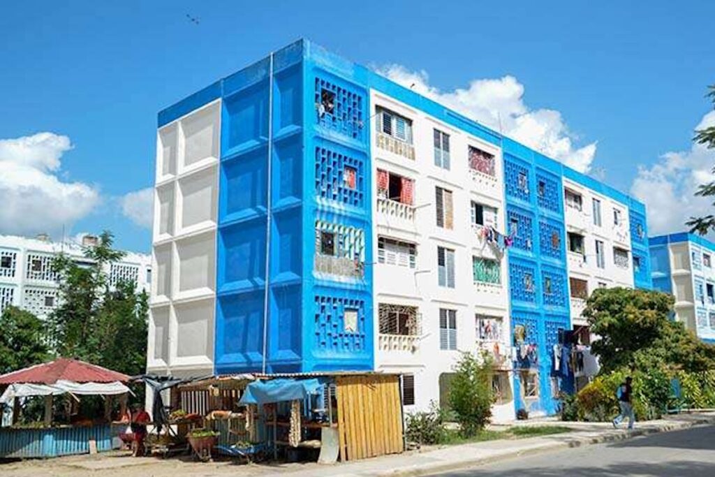 Edificio residencial colorido con balcones y árboles.