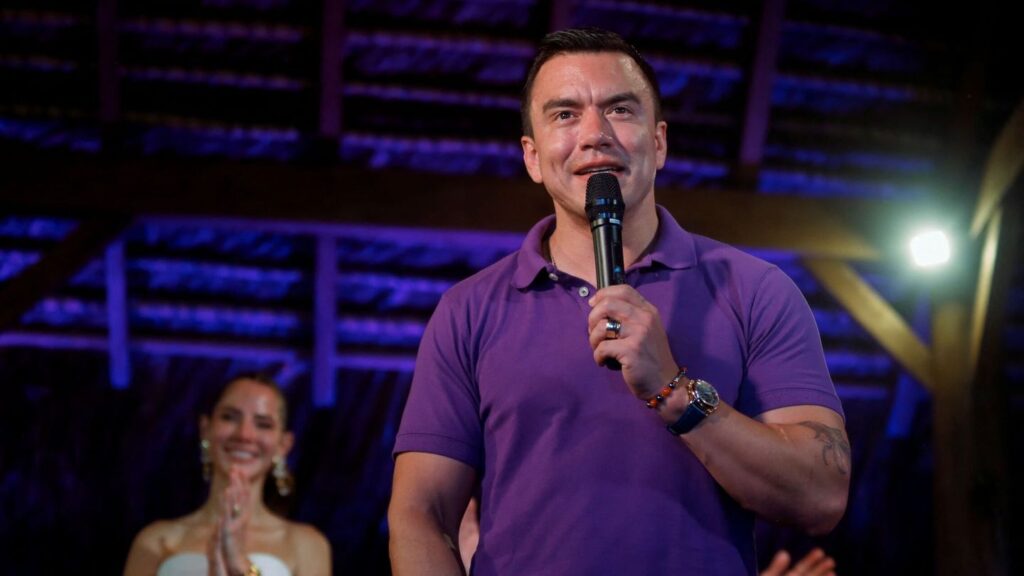 Hombre hablando con micrófono en un escenario.