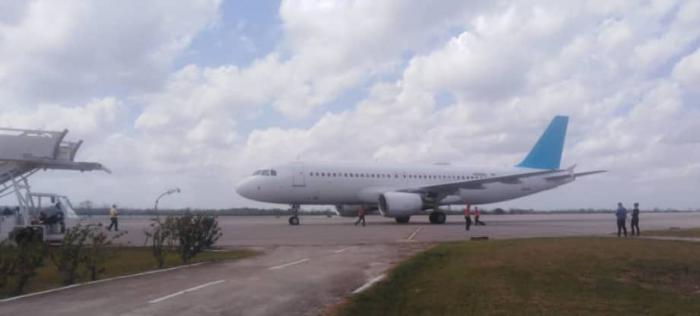 Avión en pista de aterrizaje con cielo nublado.