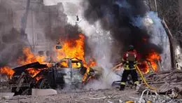 Bombero apaga incendio en auto quemado