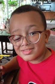 Niño sonriendo con gafas en restaurante