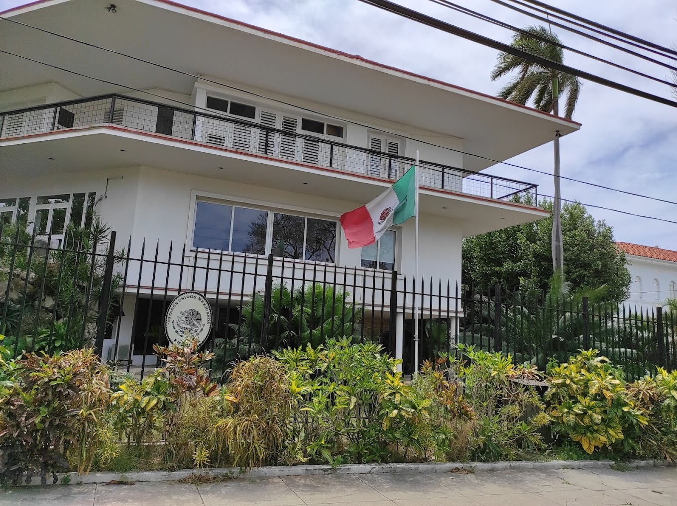 Edificio con bandera de México y jardín.