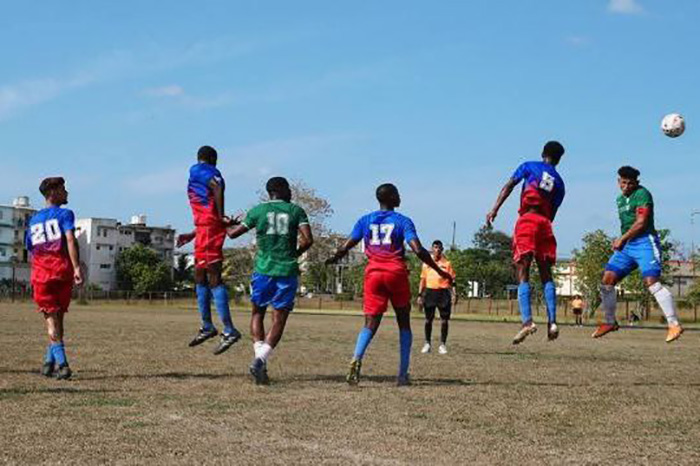 Jugadores de fútbol saltando en campo abierto