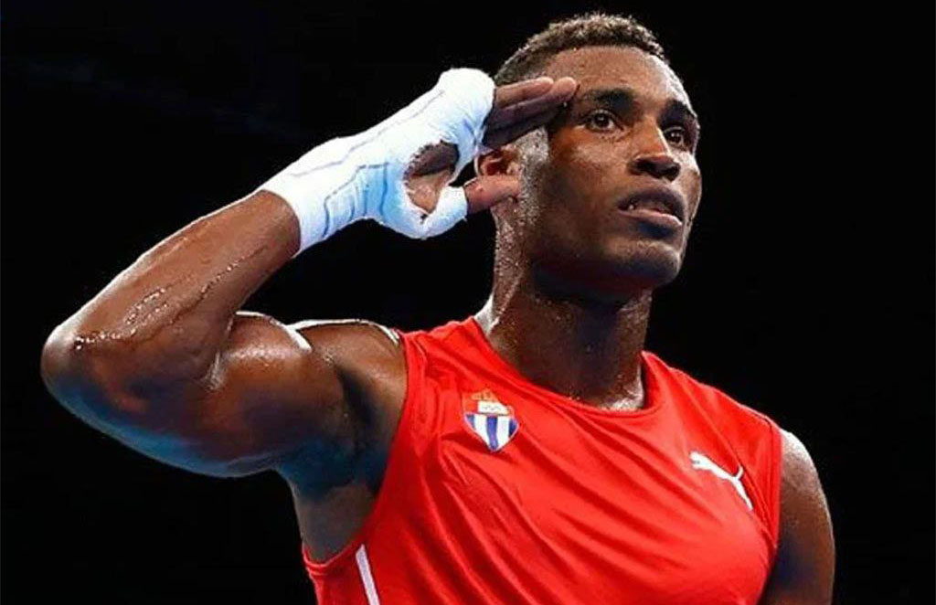 Boxeador saludando en el ring, camiseta roja.