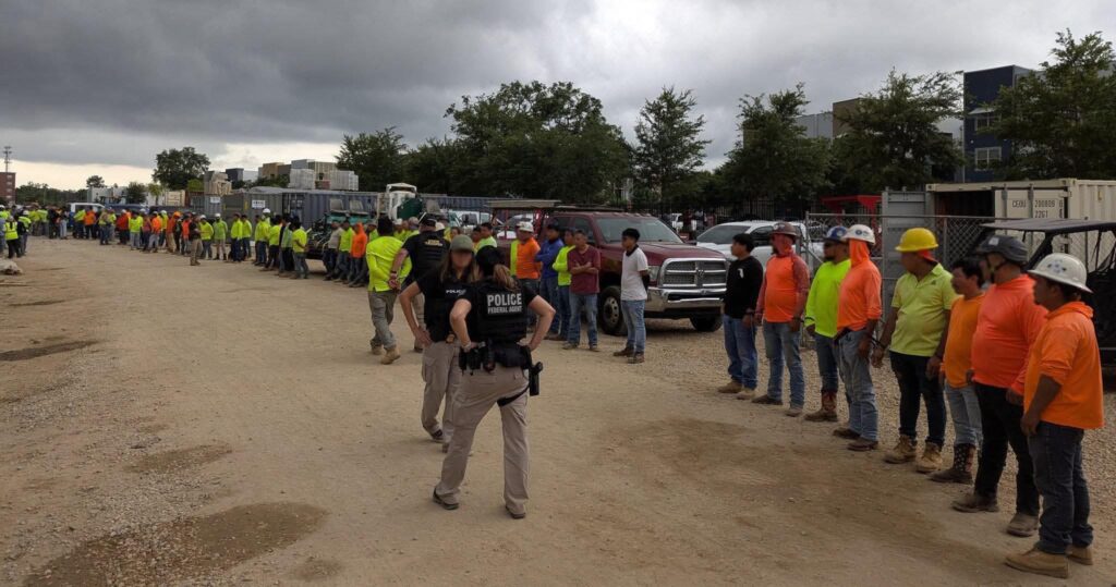 Trabajadores en fila y policías en sitio de construcción
