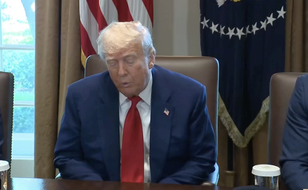 Hombre de traje azul en reunión oficial.