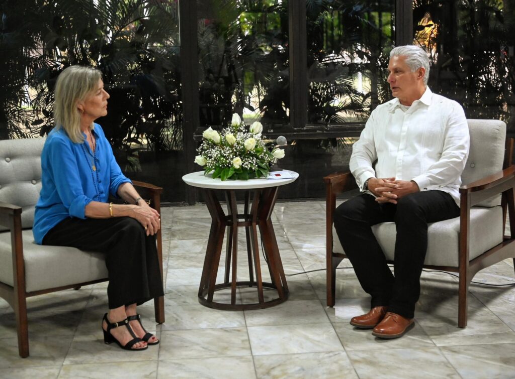 Reunión formal entre dos personas sentadas, interior elegante.