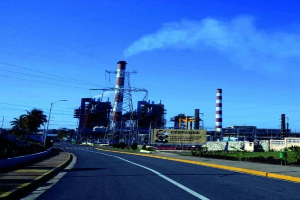 Central eléctrica con chimeneas y cartel visible