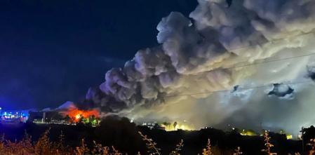 Incendio nocturno con humo sobre paisaje urbano