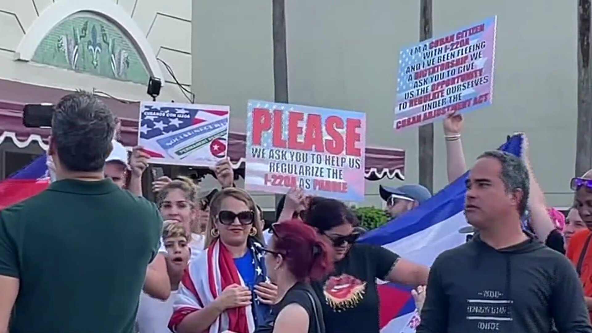 Manifestación con carteles, personas piden ayuda.