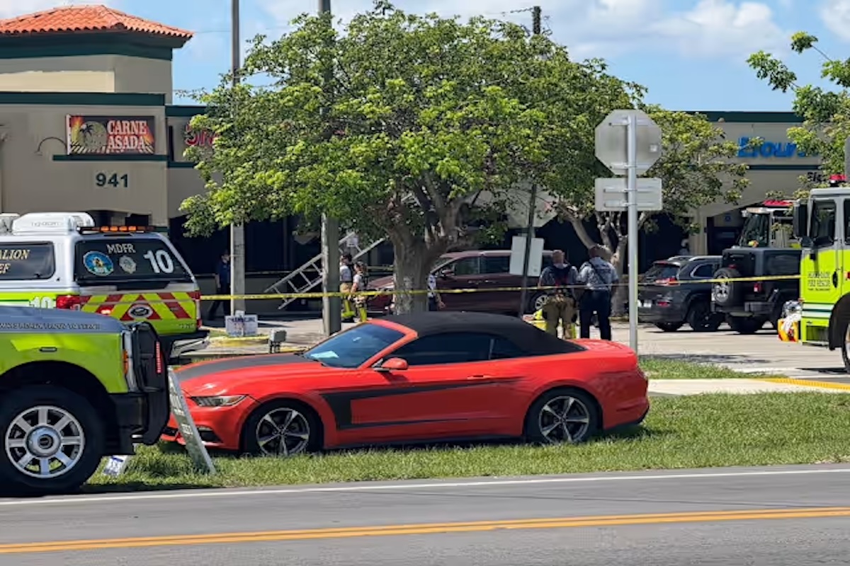 Coche rojo cerca de accidente con servicios de emergencia.