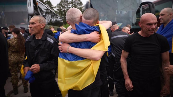 Grupo de personas abrazadas con bandera ucraniana.