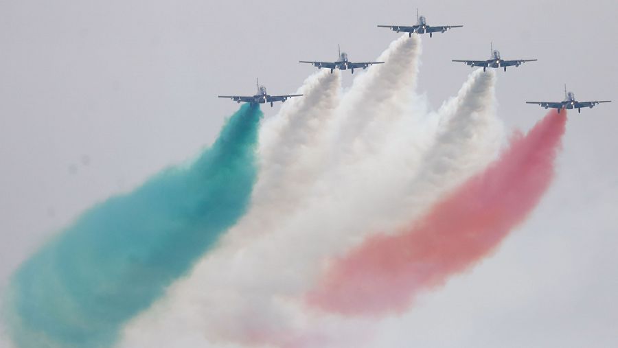 Aviones con humo tricolor en formación aérea.