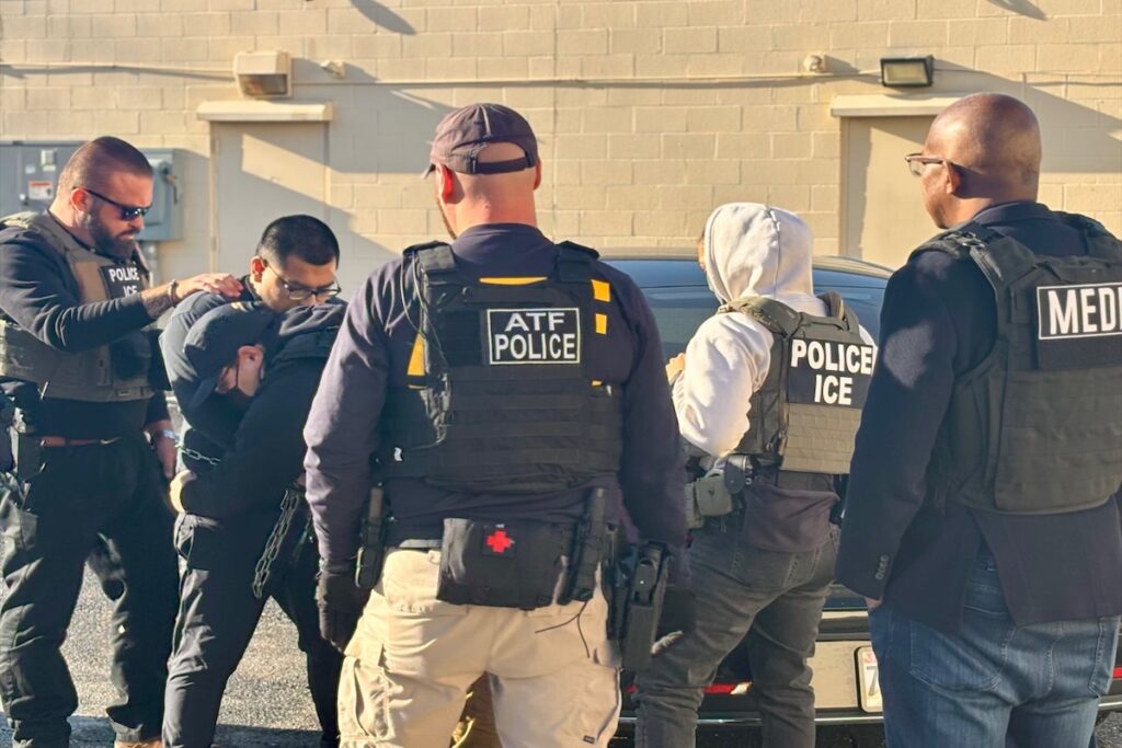 Agentes detienen a una persona esposada.