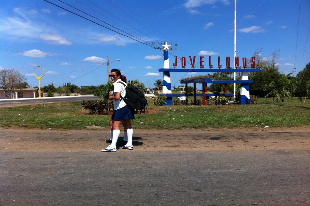 Estudiante caminando cerca de cartel de Jovellanos.