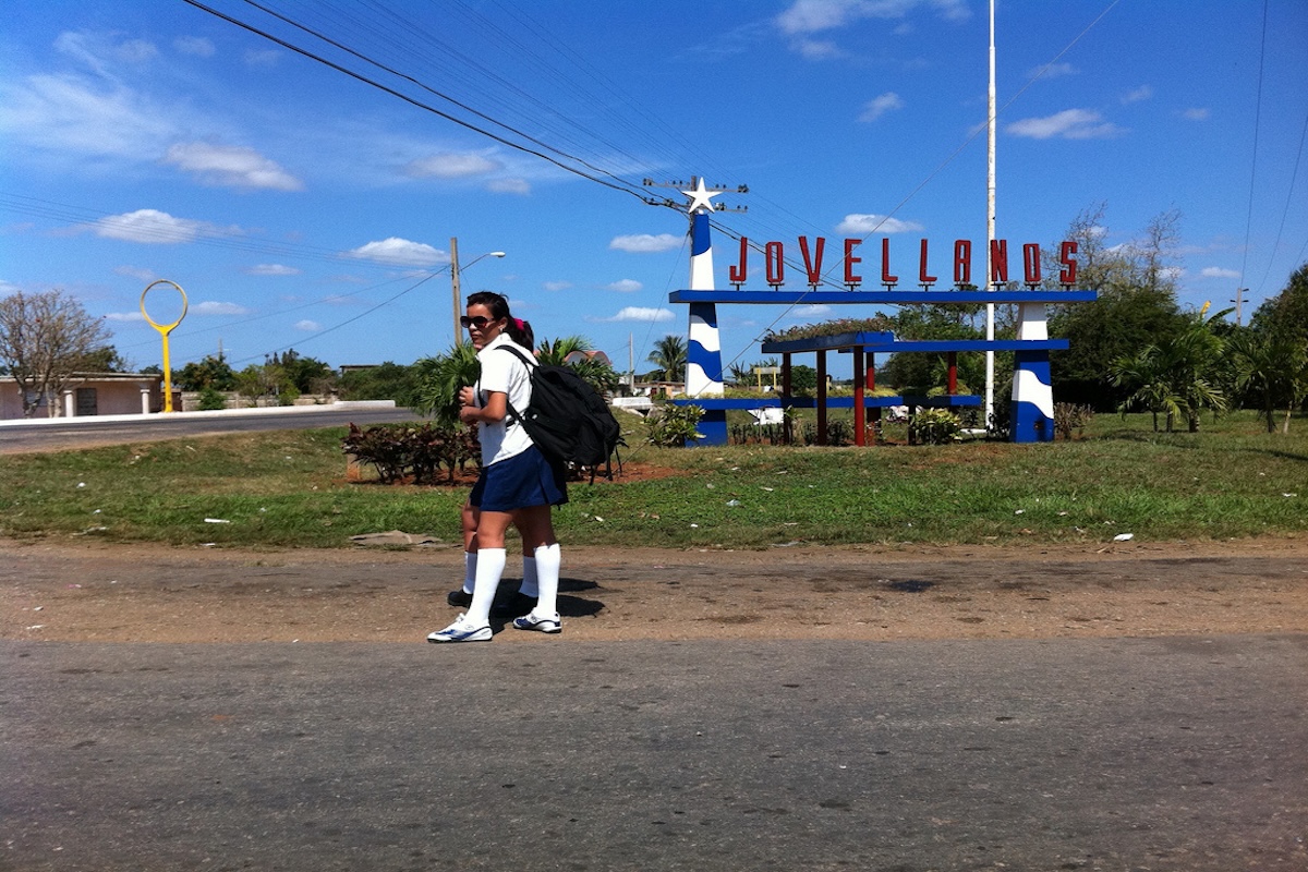 Estudiante caminando cerca de cartel de Jovellanos.