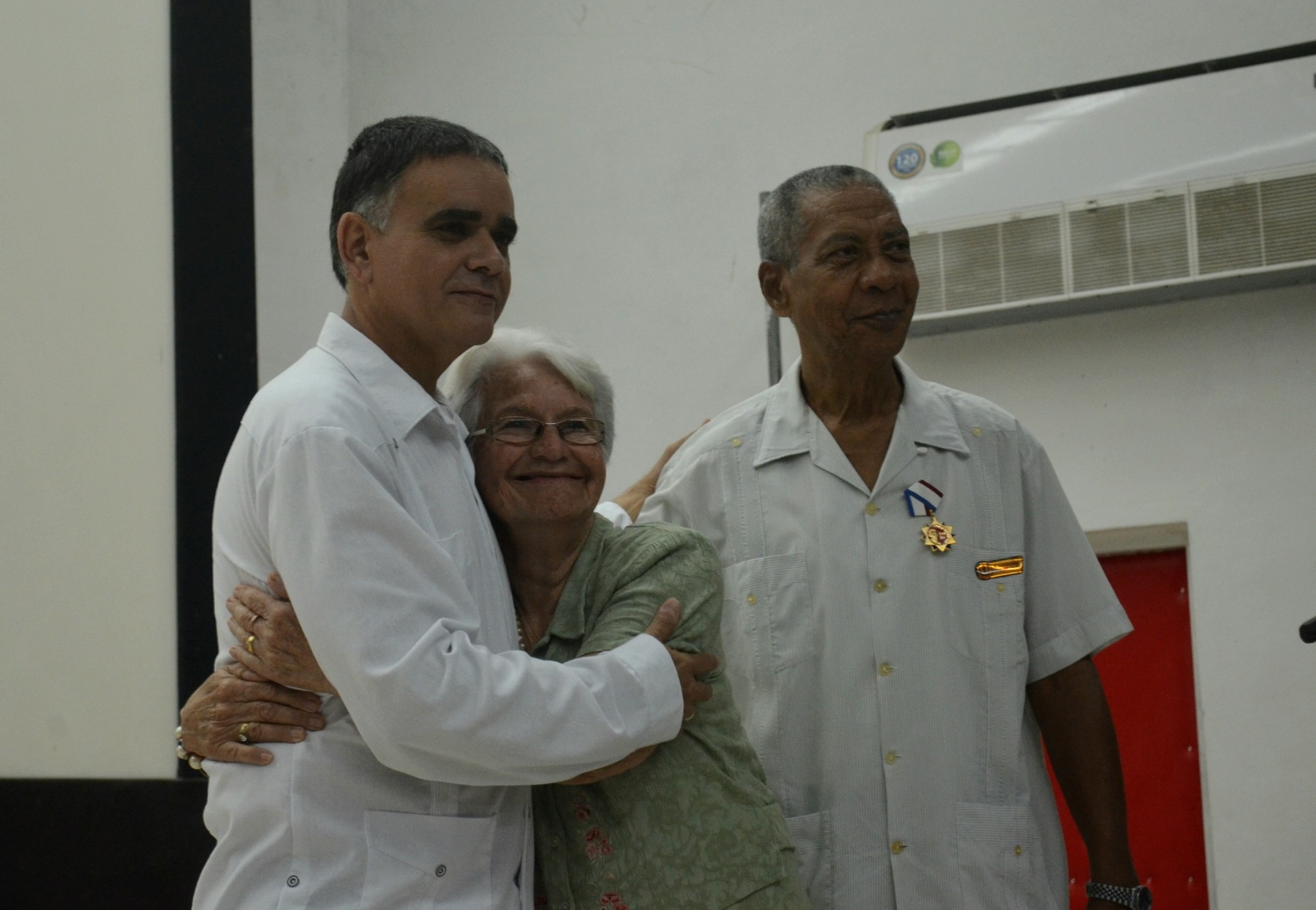 Personas abrazándose en un evento interior