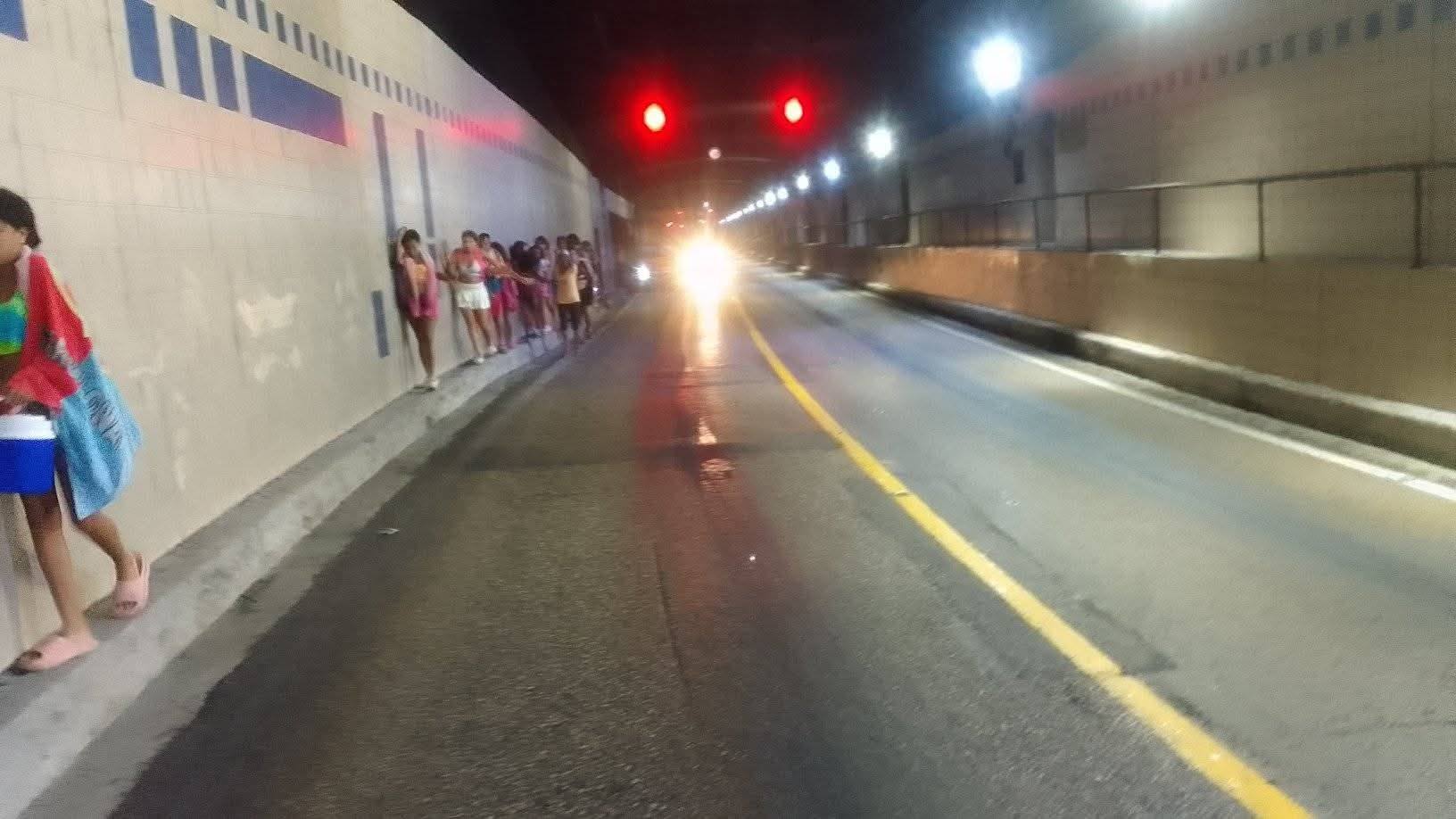 Personas caminando en un túnel iluminado por la noche.
