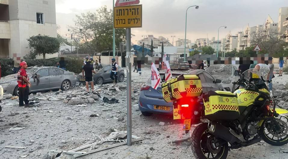 Daños tras explosión en zona urbana, escombros y vehículos.