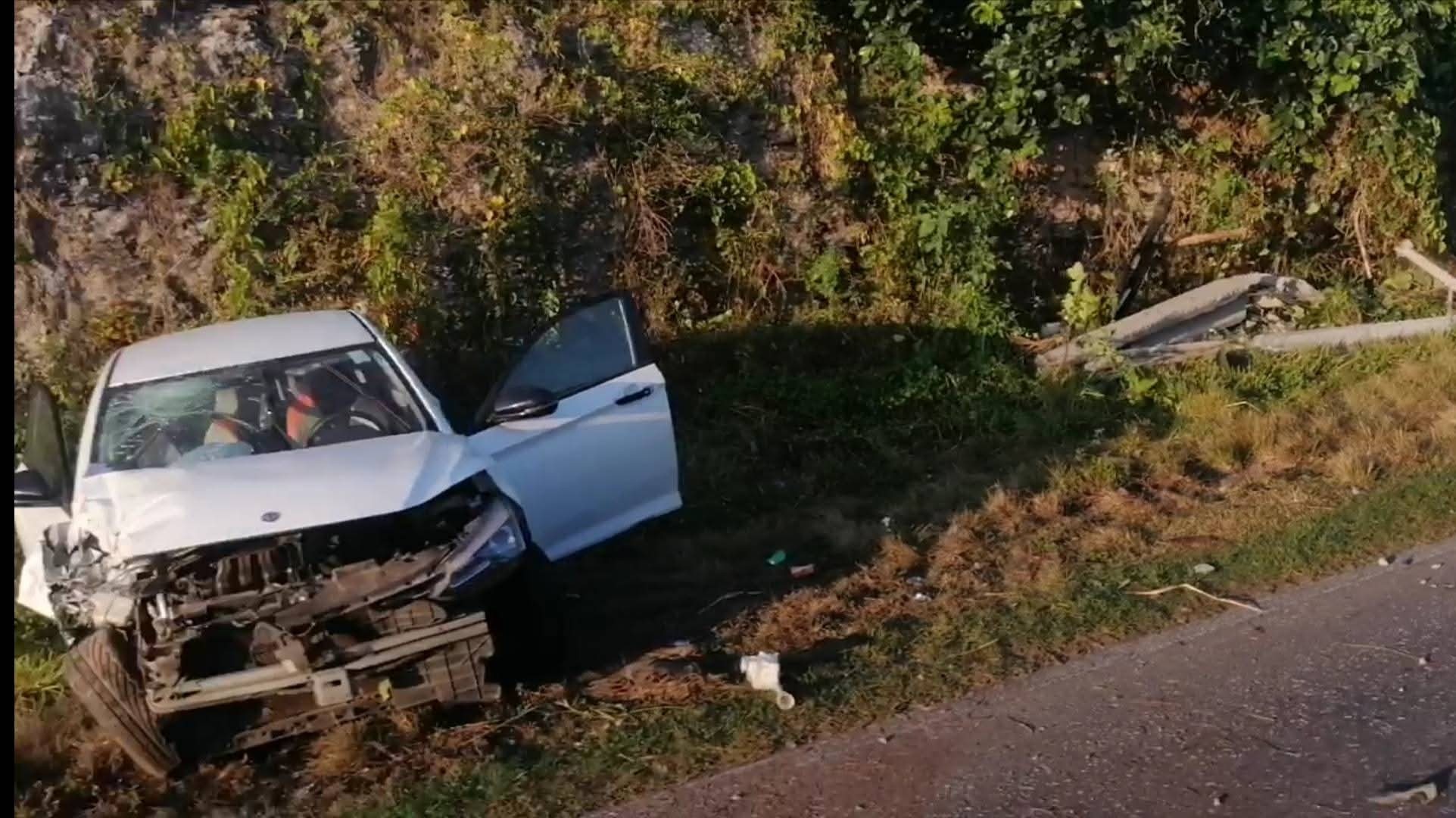 Coche blanco accidentado junto a la carretera