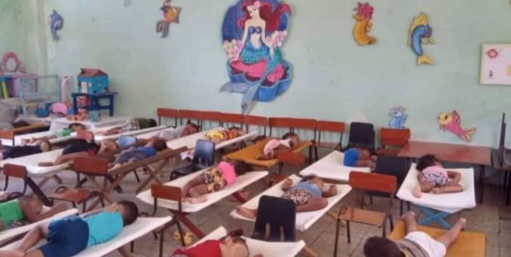 Niños durmiendo en guardería decorada con sirena.