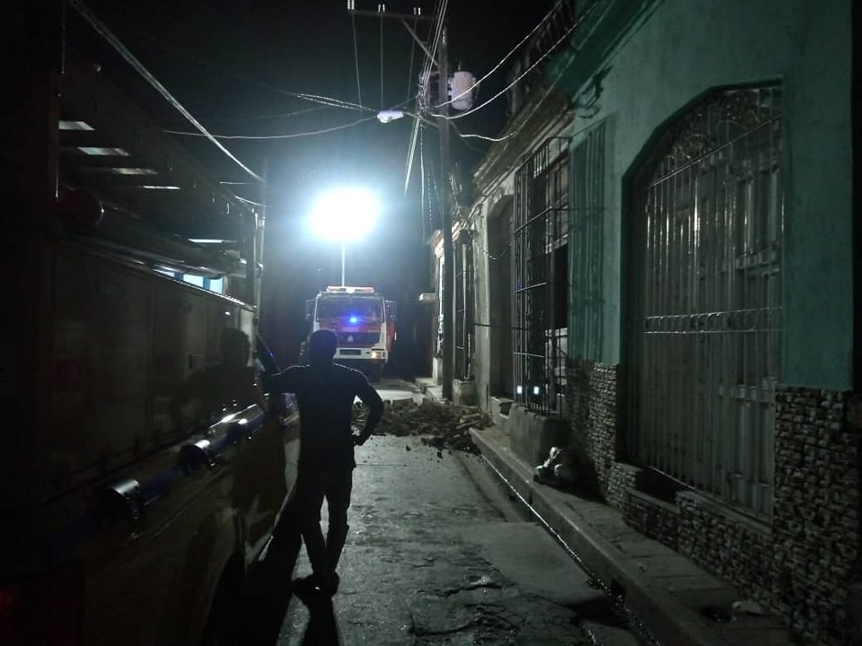 Calle oscura con camión de bomberos iluminado.