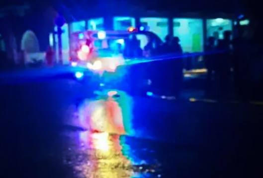 Ambulancia con luces encendidas en noche lluviosa