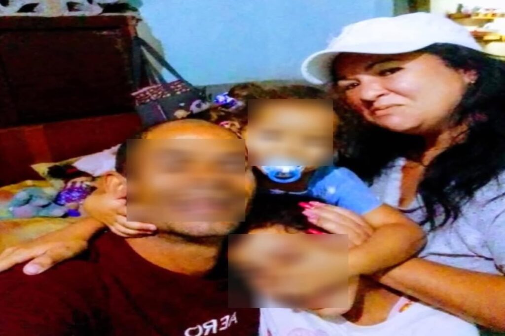 Familia sonriente abrazando a niños pequeños en casa.