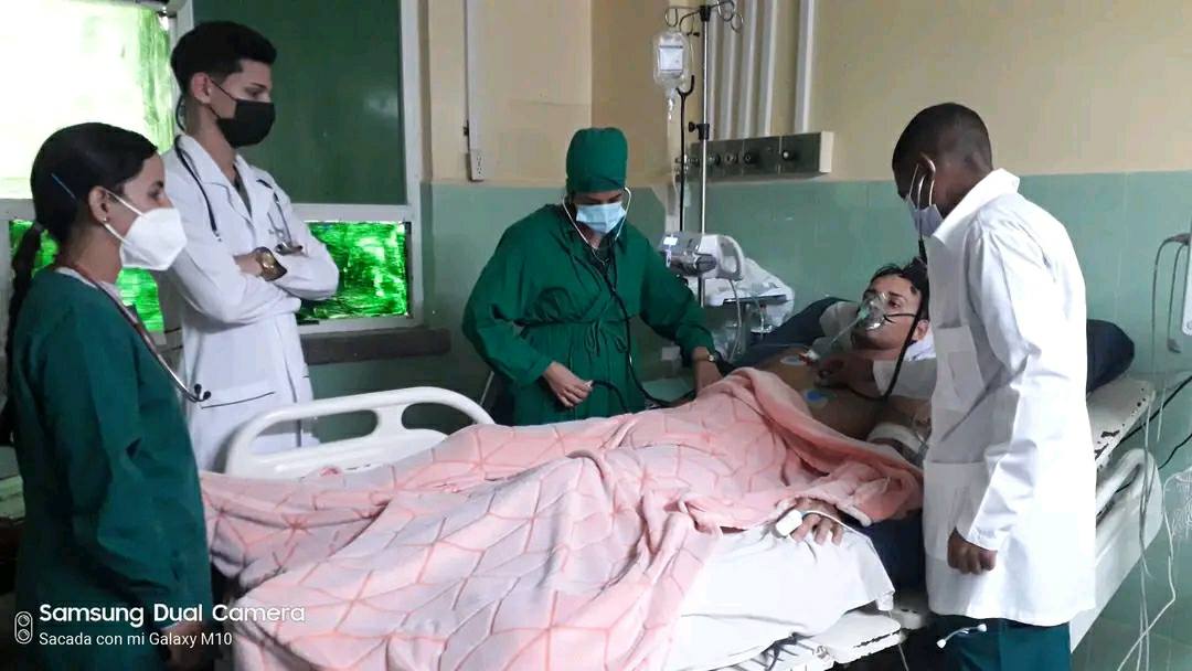 Médicos revisan paciente en hospital.