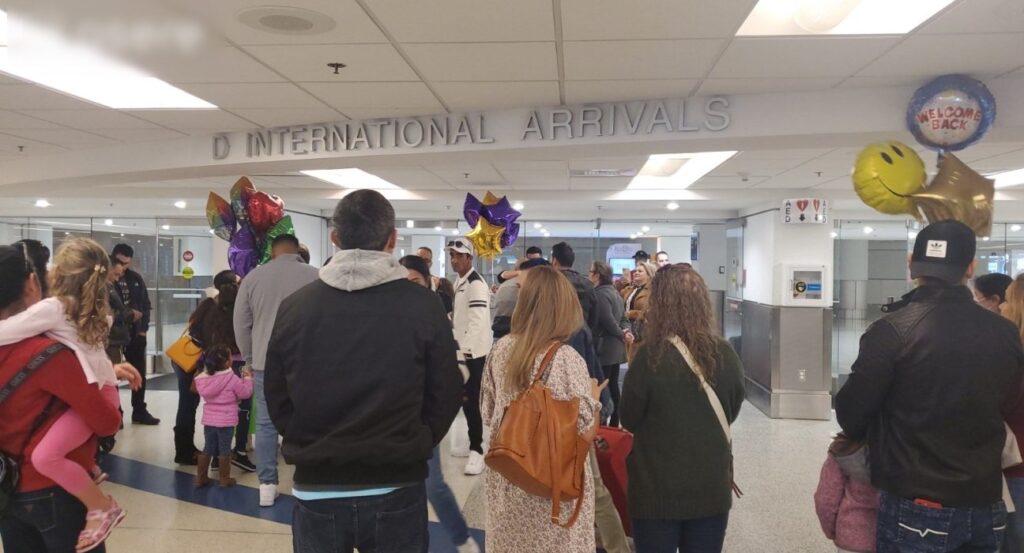 Personas en llegadas internacionales de aeropuerto con globos.