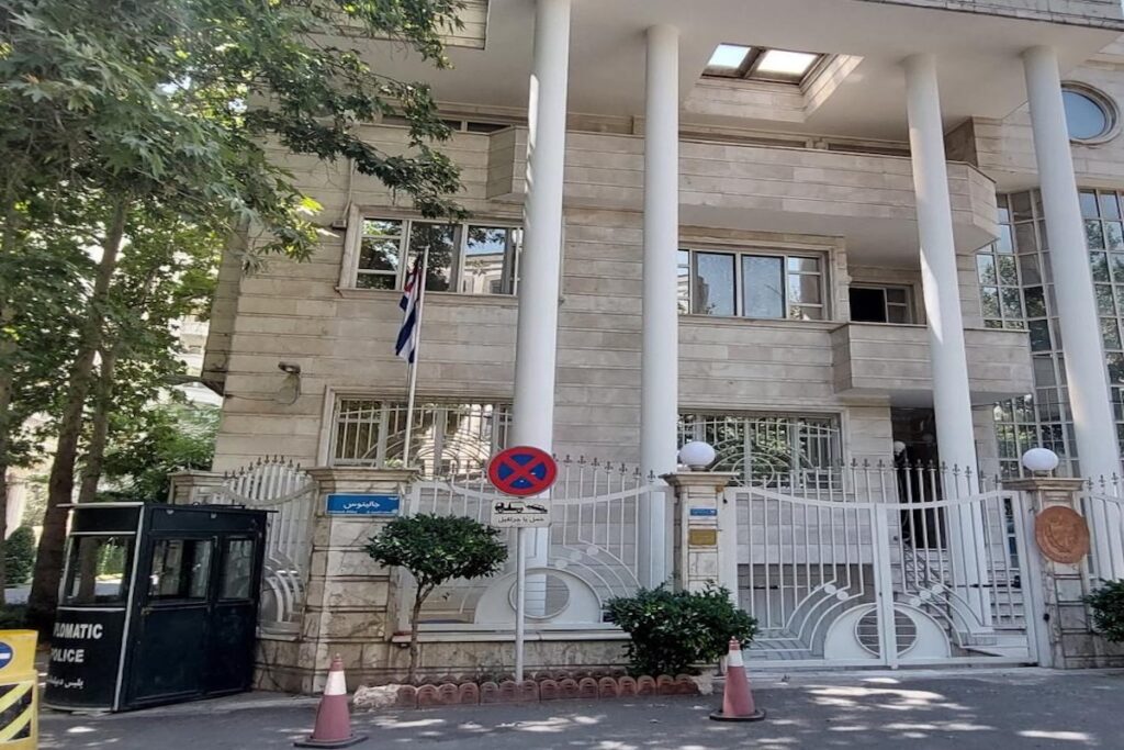 Embajada con bandera e imponente fachada blanca.