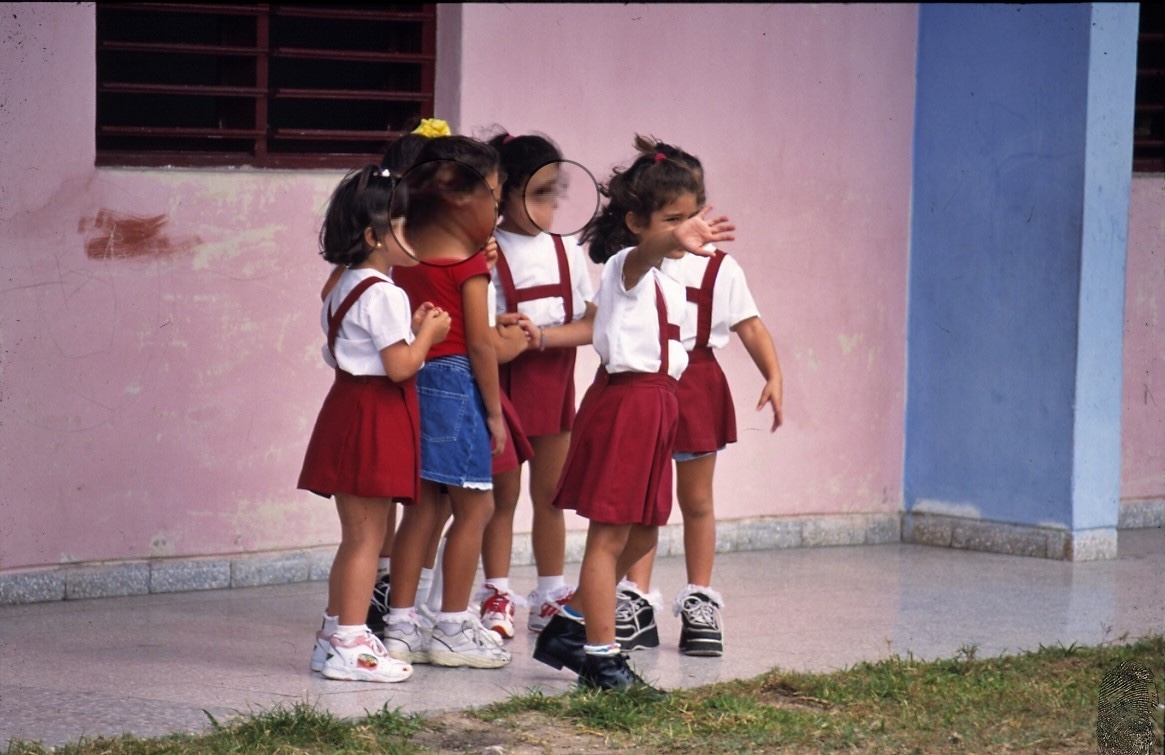 Niñas en uniforme escolar jugando afuera.