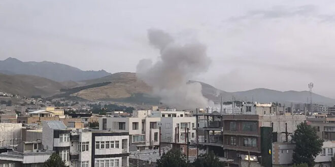 Humo sobre ciudad con montañas atrás