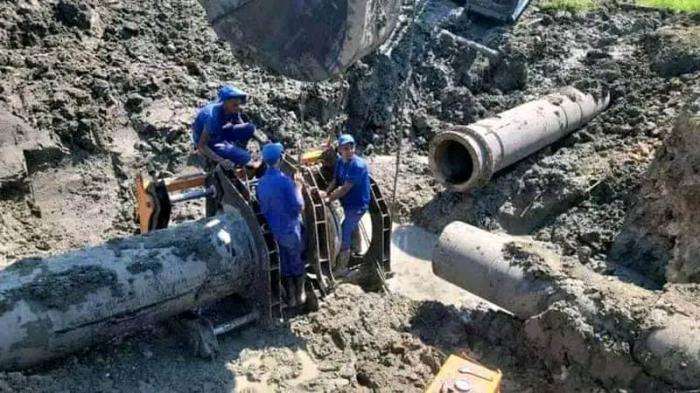 Trabajadores reparan tubería grande en obra