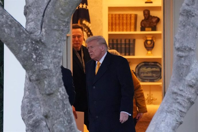 Personas saliendo de una sala con estanterías.